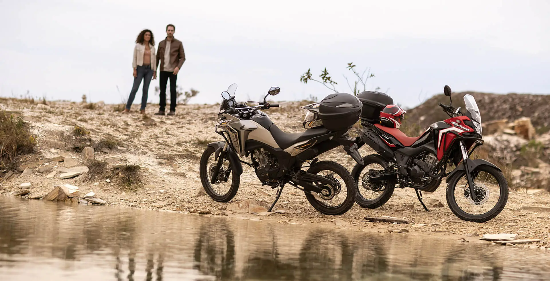 casal observando duas motos Honda XRE Sahara 300