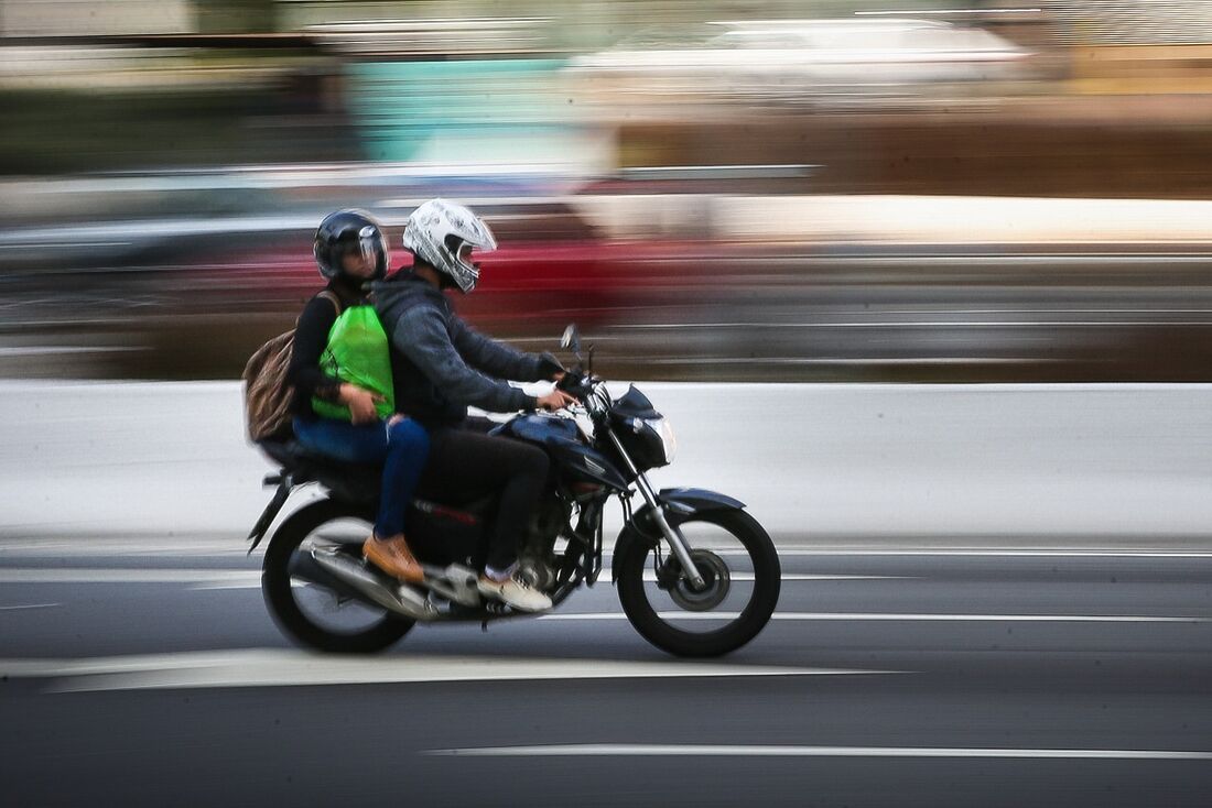 Motorista de Uber moto levando passageiro na garupa