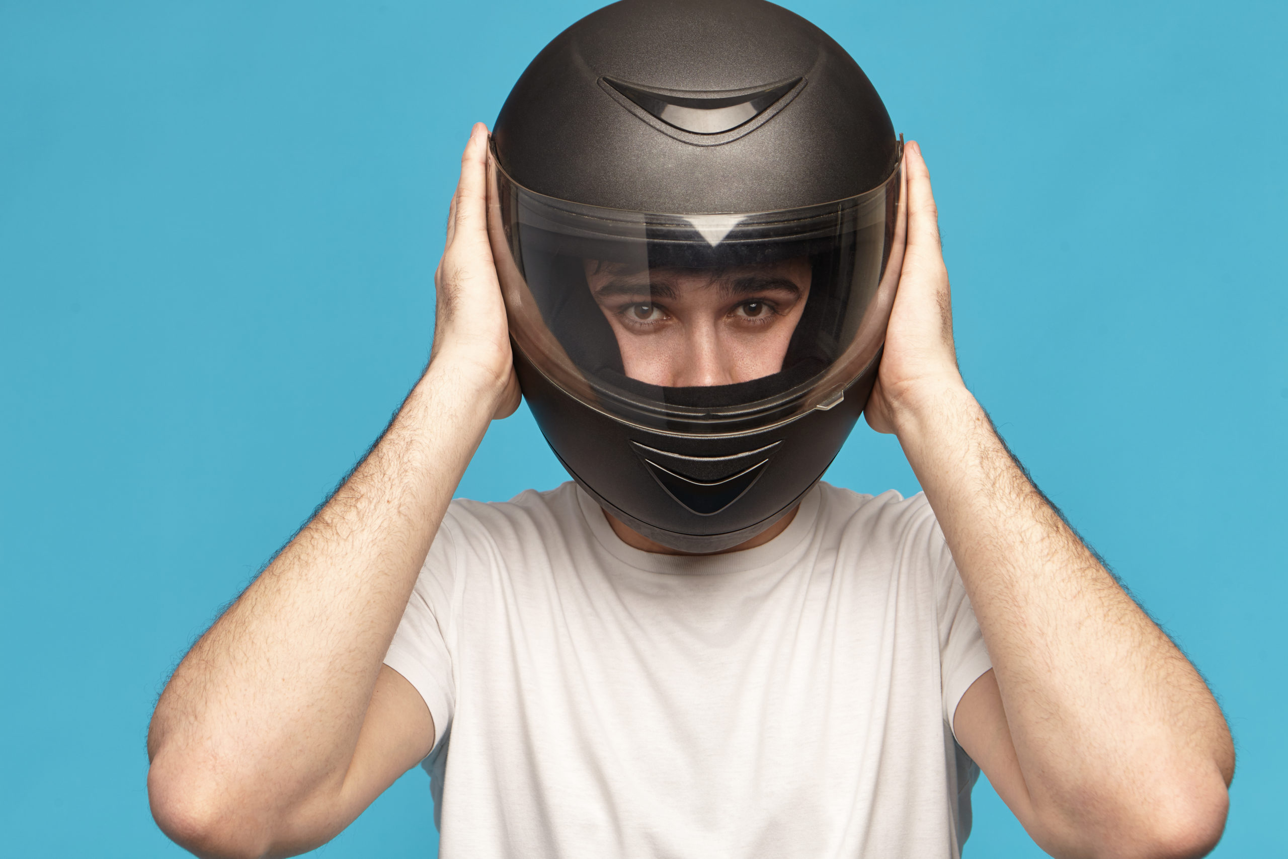 Homem com capacete de motociclismo na cabeça