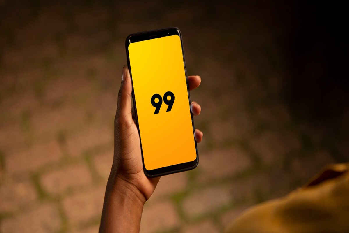 Close na mão de uma pessoa segurando um celular com o app 99 aberto